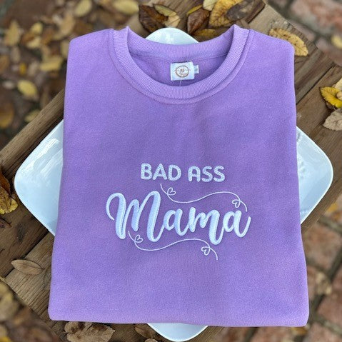 Introducing the ultimate expression of feminine strength - The Bad Ass Mama Lavender Embroidered PPD Crewneck Sweatshirt. A perfect blend of comfort, style, and attitude that will keep you feeling confident all day long!  In search of a sweatshirt that not only provides comfort but also makes a statement? Look no further than the Bad Ass Mama Lavender Embroidered PPD Crewneck Sweatshirt.