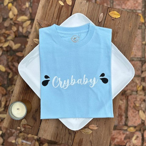 Our "Crybaby" t-Shirt for women is professionally screen printed featuring a soothing sky blue shirt with white cursive lettering and two black teardrops on each side. Postpartum Depression can be a frightening experience, and you can face multiple emotions at the same time. After giving birth to my son, I cried constantly for weeks for no apparent reason. Needless to say, I just felt very sad. I recall one occasion when my sister asked me if I was okay, and I immediately burst into tears.